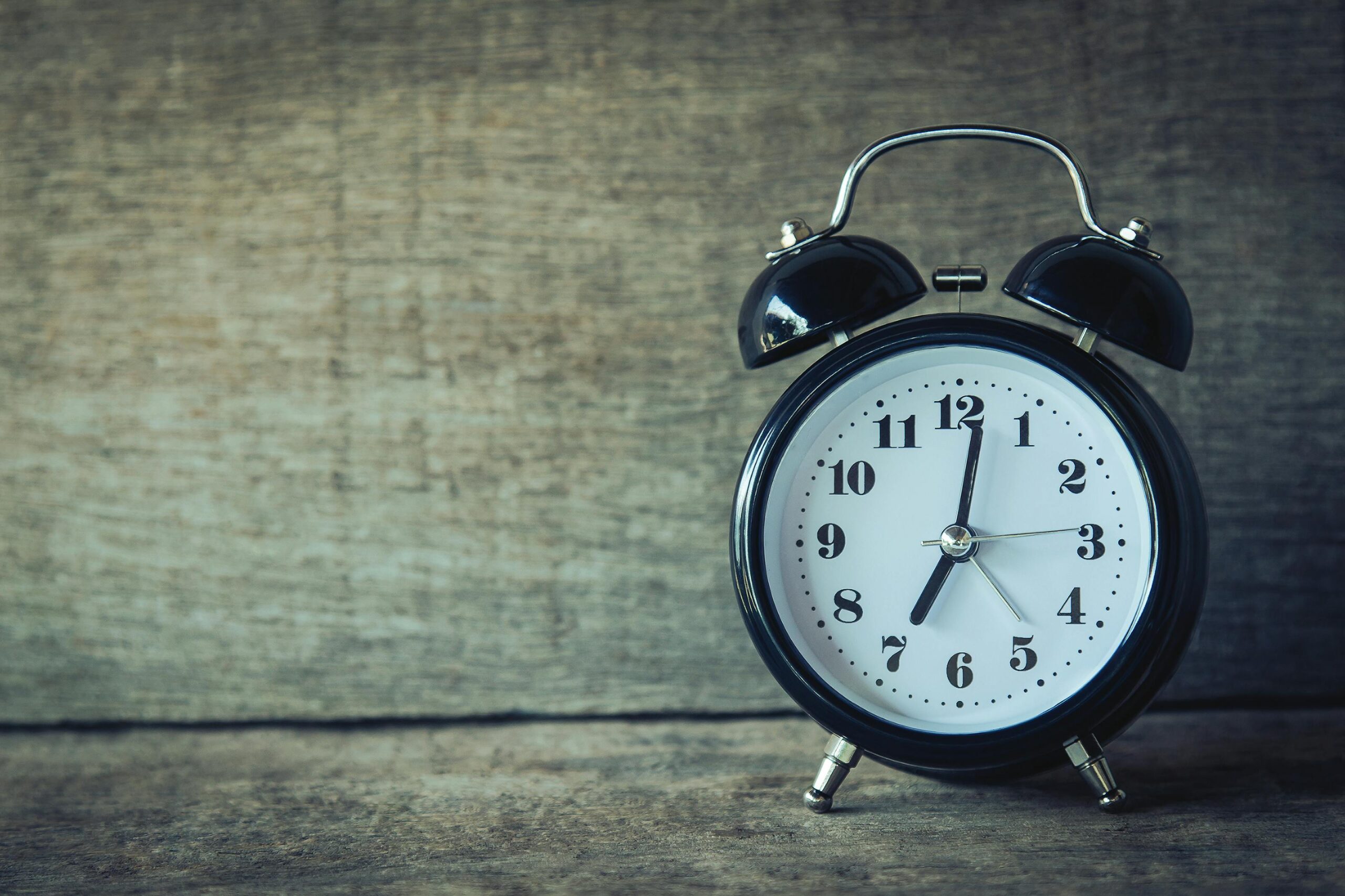 Clock sitting on table. Time reads 7:02