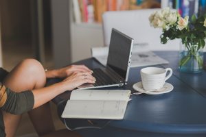 image of someone typing with laptop on counter